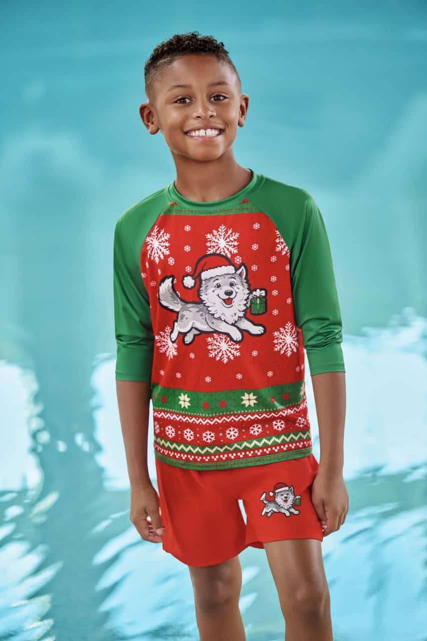 a boy wear a santa themed swimear in red and green